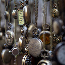 Antique pocket watches hanging in a display.